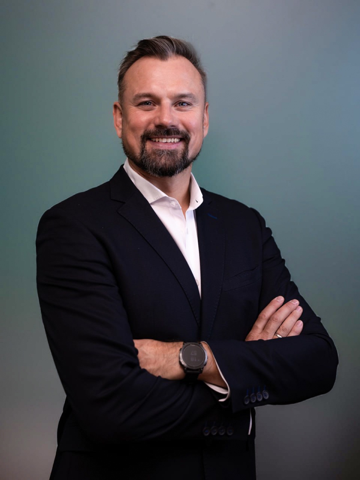 Founder portrait in dark suit on green-blue gradient backdrop — corporate headshot by Best Alex Shots, Vienna