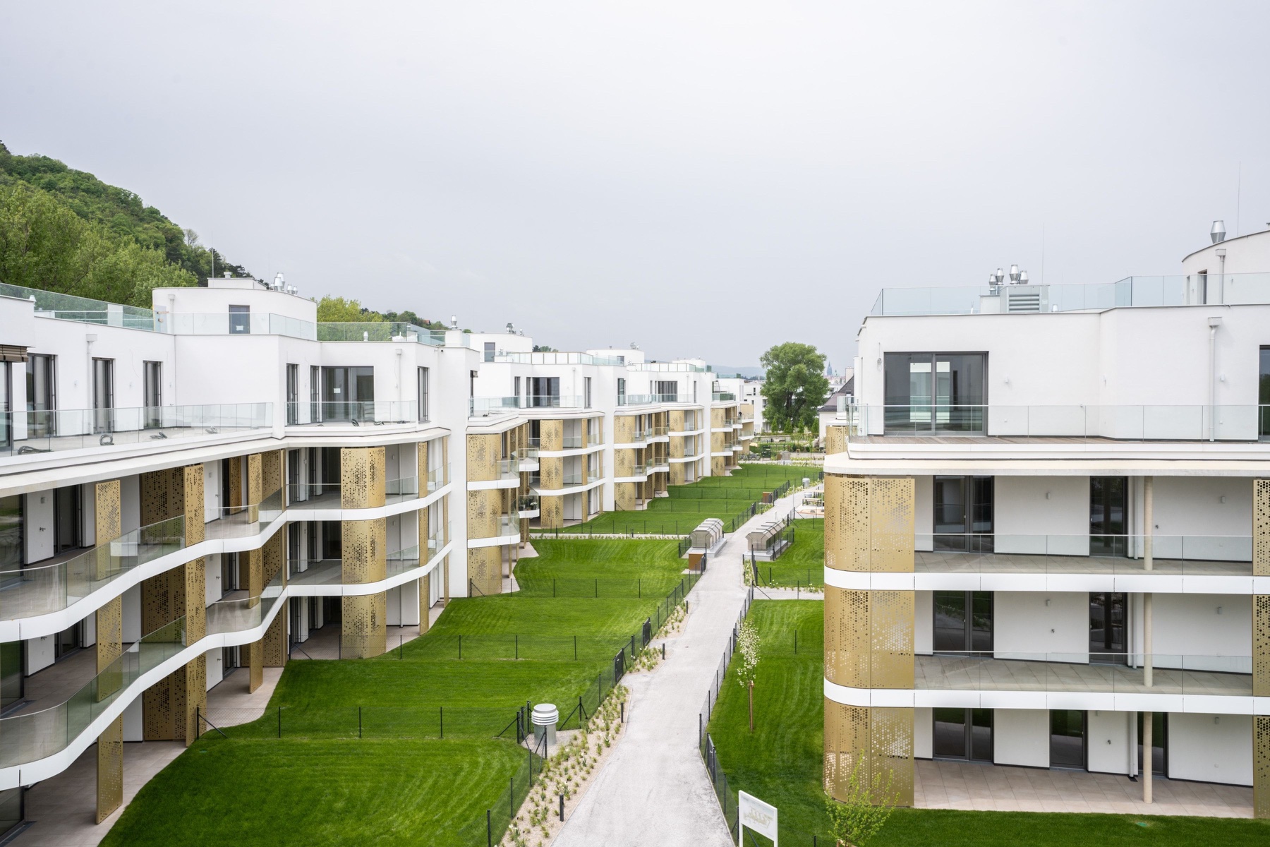 Modern white residential courtyard with signature golden balcony details, Vienna — Best Alex Shots