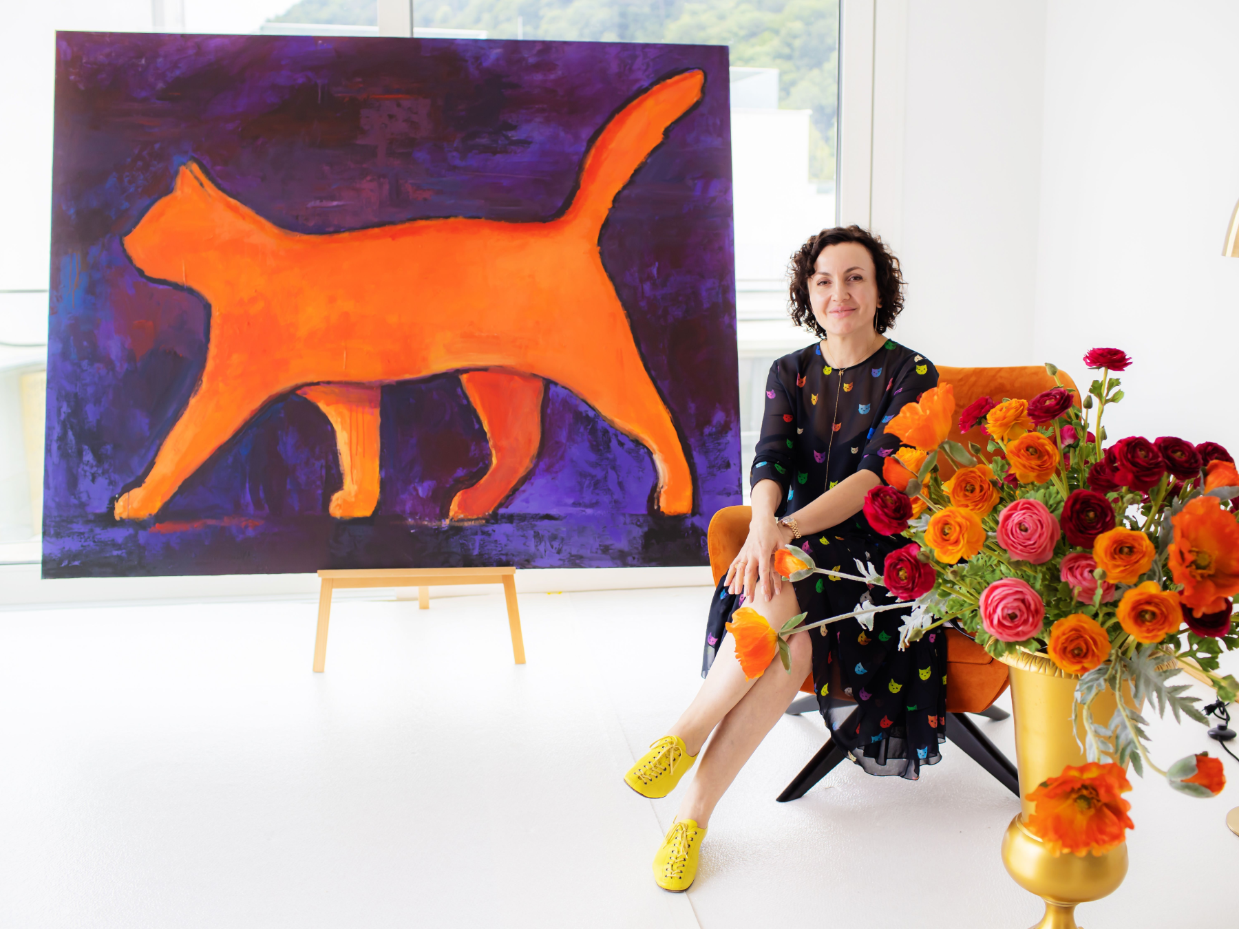 Curator beside orange cat painting at Vienna art exhibition
