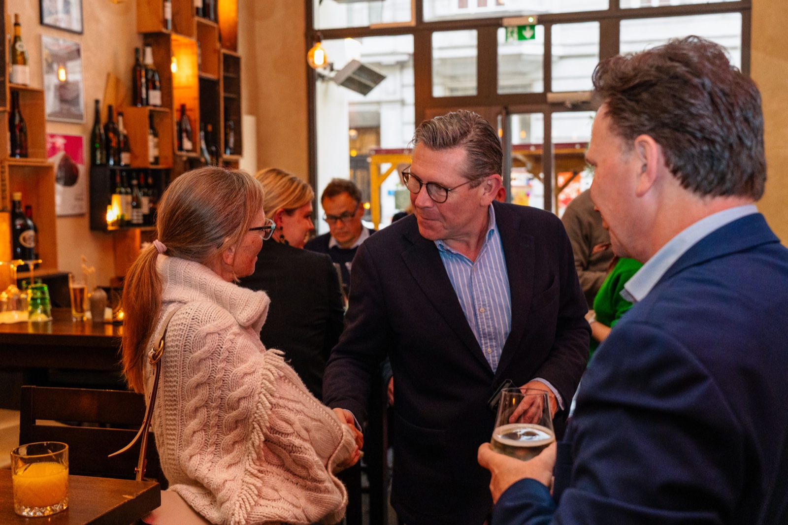 Networking event conversation in a brick-walled venue, Vienna — event photography by Best Alex Shots