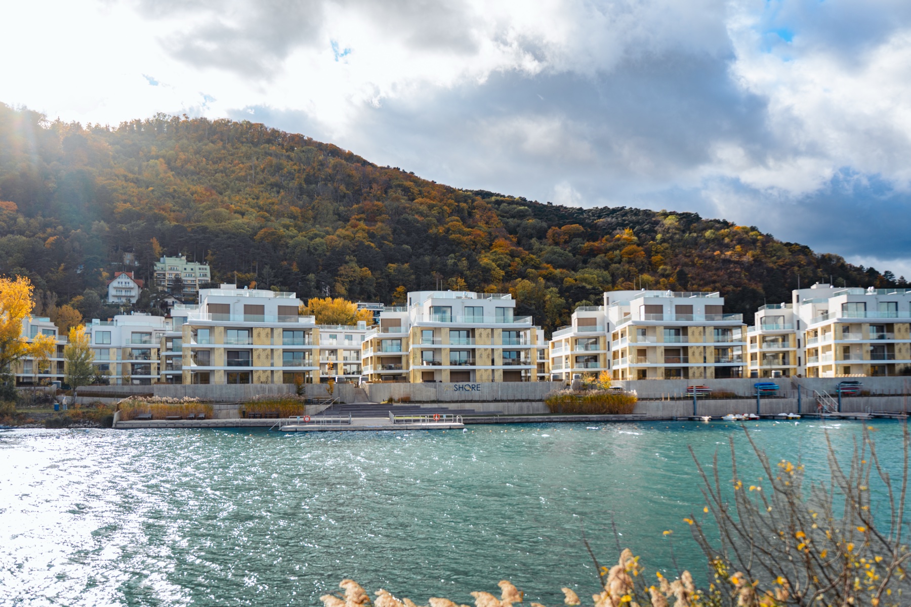 The Shore complex in autumn light with calm water — drone photo by Best Alex Shots, Vienna